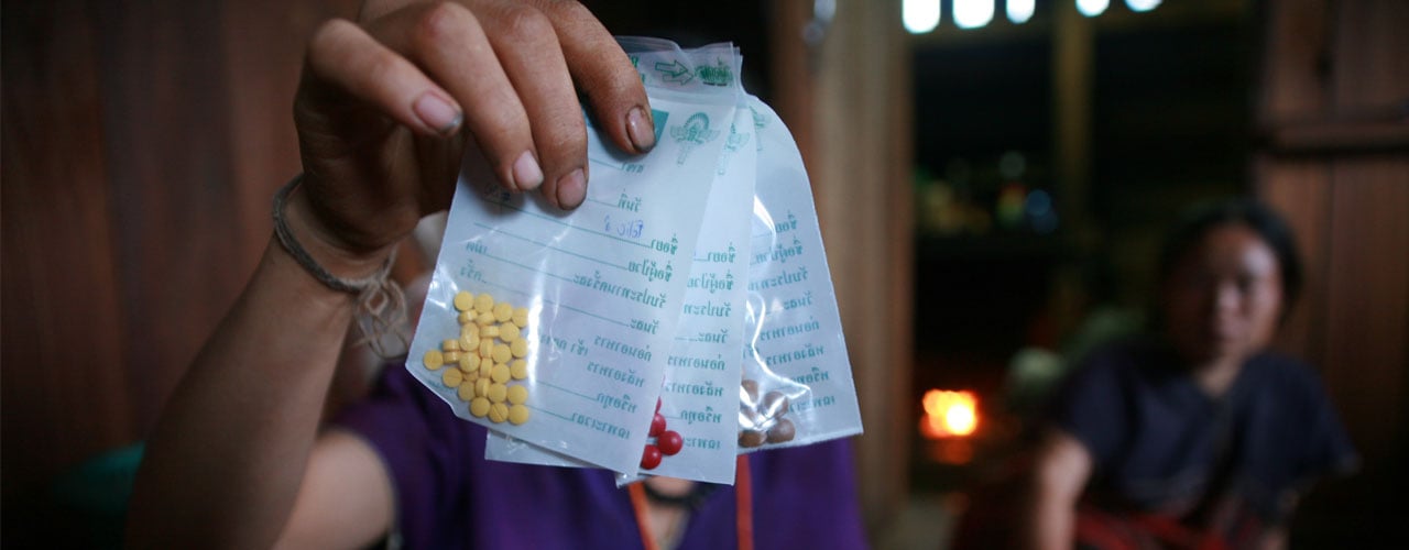 Close up of hand holding tablets in bags