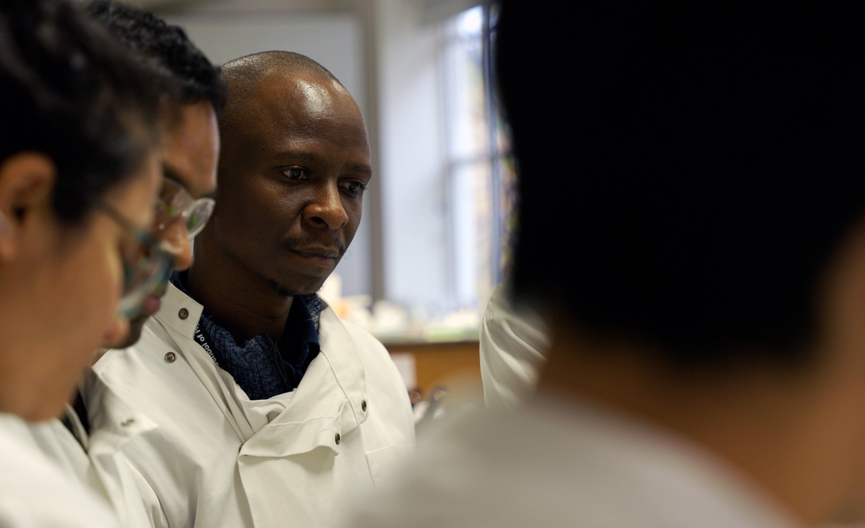 Andrew (third person from the left) and his fellows in a DTM&amp;H laboratory session.