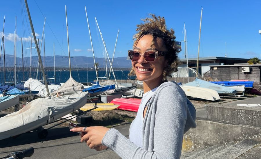 Student, Alexandra, stood in front of multiple sailboats.