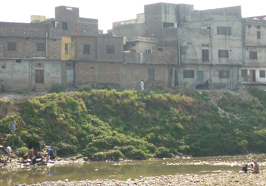 Rubbish and effluent flow into a river in Pakistan as people wash and bathe in the dirty water Rubbish and effluent flow into a river in Pakistan as people wash and bathe in the dirty water