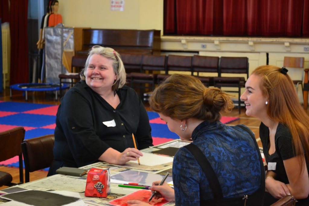 EHR Group cancer workshop women sat at table painting