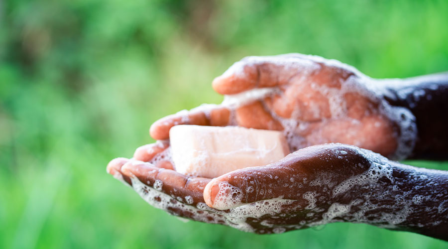 Young man using soap and washing hands