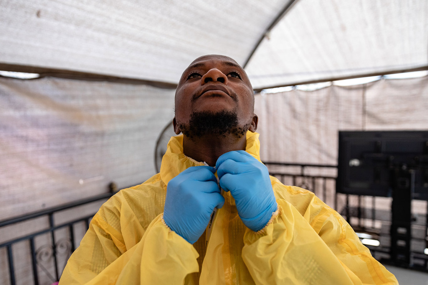Dr Abdulmajid Suleiman Musa closes the final button on his personal protective equipment (PPE) suit during a training session with Nigeria Centre for Disease Control (NCDC) staff in Keffi, Nasarawa state. The UK Public Health Rapid Support Team worked with the NCDC during a Lassa Fever outbreak in 2018. Credit: Louis Leeson/LSHTM