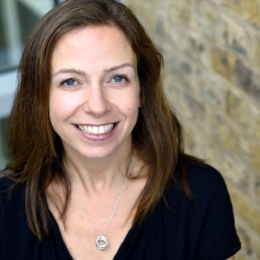 White woman with shoulder length brown hair smiling