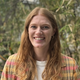 White woman with auburn hair smiling