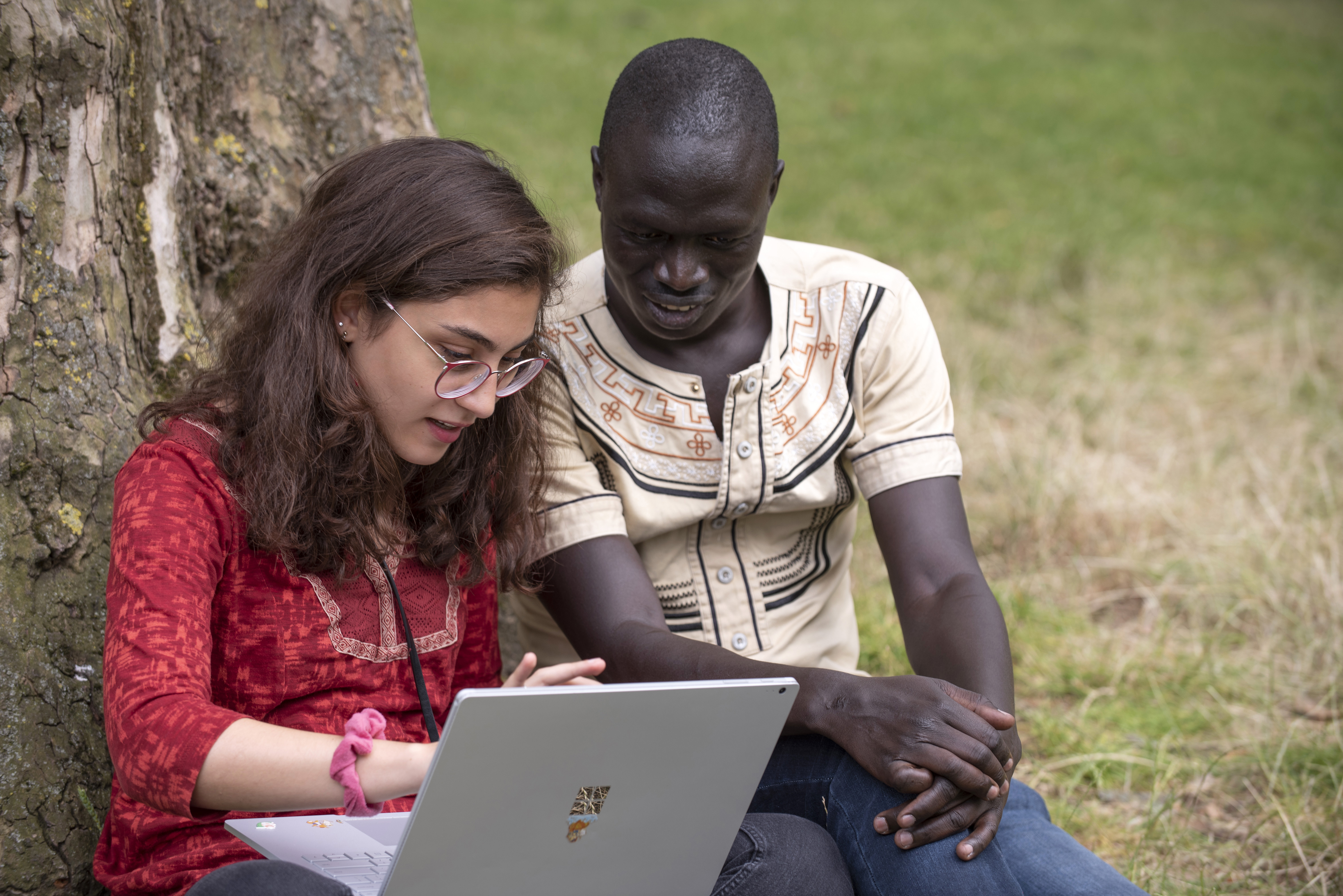 Two individuals looking at a laptop
