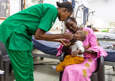 A nurse giving polio vaccine to child in a clinic