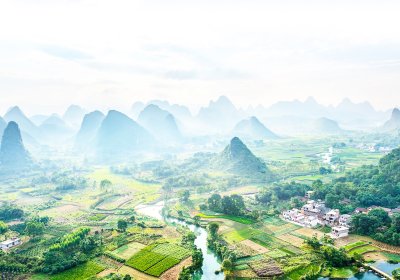 Image of mountains with a river running through and a human settlement