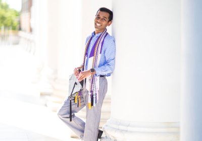 Student, Mahdin, holding a graduation cap.