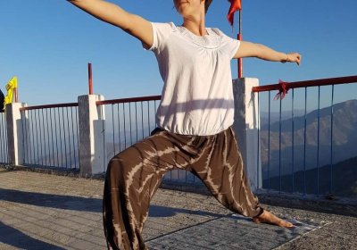 Image of a woman in a yoga pose with mountains behind