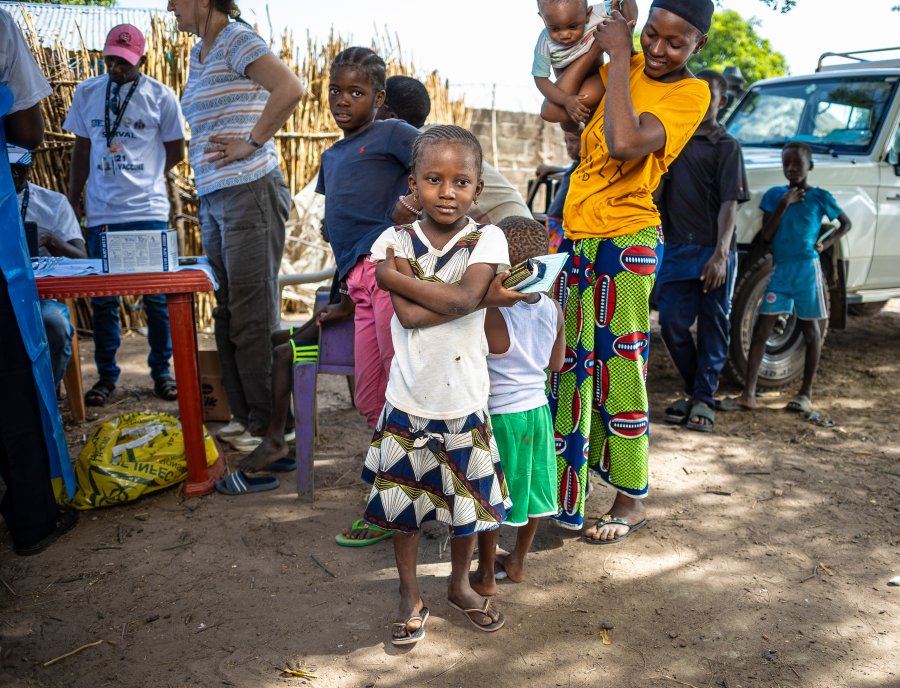 A vaccinated child standing happily in a local community A vaccinated child standing happily in a local community