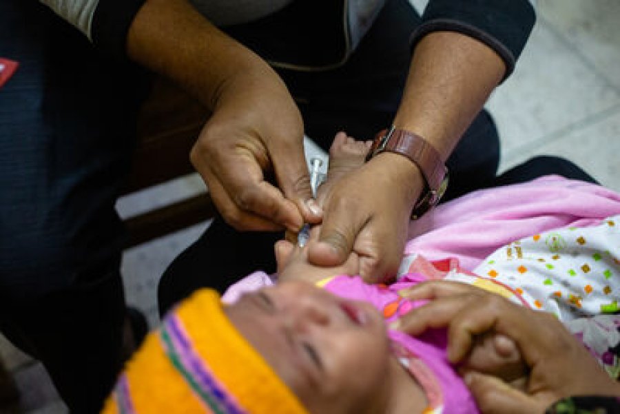 A doctor prepares a dose of measles vaccine for a young child A doctor prepares a dose of measles vaccine for a young child