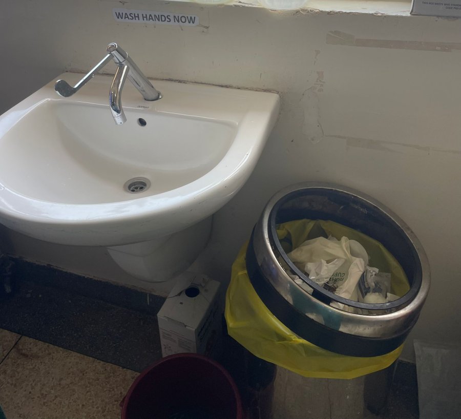 A sink in a healthcare setting with improvised soap containers and a waste bin. Credit: Lauren Hookham