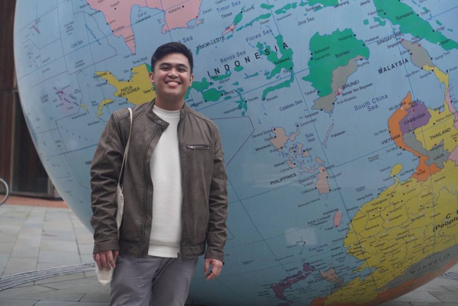 Raymond Naguit Student, Raymond, stood in front of a globe.