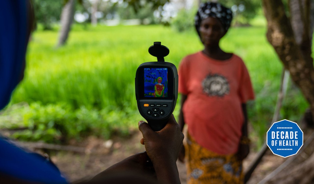 A field worker from MRC Unit The Gambia at LSHTM uses a thermal imaging camera to measure a mother and her unborn baby's temperature in Keneba as part of a study looking at the impact of heat stress on pregnant farmers. Credit: Louis Leeson/LSHTM A field worker from MRC Unit The Gambia at LSHTM uses a thermal imaging camera to measure a mother and her unborn baby's temperature in Keneba as part of a study looking at the impact of heat stress on pregnant farmers. Credit: Louis Leeson/LSHTM