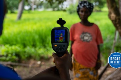 A field worker from MRC Unit The Gambia at LSHTM uses a thermal imaging camera to measure a mother and her unborn baby&#039;s temperature in Keneba as part of a study looking at the impact of heat stress on pregnant farmers. Credit: Louis Leeson/LSHTM